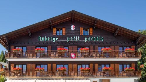 un edificio con un balcón con flores. en Petit Paradis, en Crans-Montana