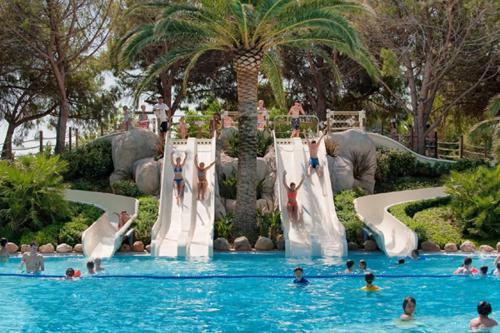 um grupo de pessoas em uma piscina com um parque aquático em Mobile Homes by KelAir at Playa Montroig Camping Resort em Tarragona