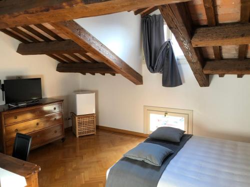 a bedroom with a bed and a television and wooden ceilings at Residenza Privata Pedrotti in Vicenza