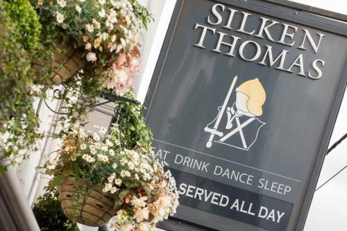 a sign for a restaurant with flowers in baskets at Silken Thomas Accommodation in Kildare