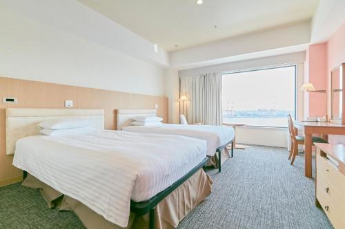 a hotel room with two beds and a large window at Hotel Seagull Tenpozan Osaka in Osaka