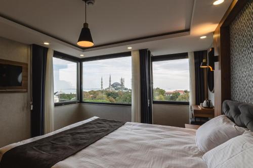 a bedroom with a large bed and a large window at World Heritage Center Hotel in Istanbul