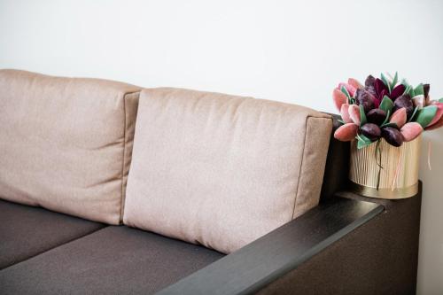 eine Couch mit einer Vase Blumen auf dem Tisch in der Unterkunft Центр міста! Затишні квартири в новобудові! in Uschhorod