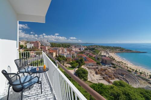 einen Balkon mit 2 Stühlen und Strandblick in der Unterkunft H10 Imperial Tarraco 4 Sup in Tarragona