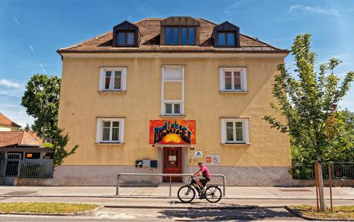 a person riding a bike in front of a building at Radfahrerherberge Krems in Krems an der Donau