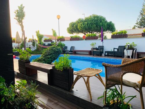 eine Terrasse mit einem Pool, einem Tisch und Stühlen in der Unterkunft RUMAH Esposende in Esposende