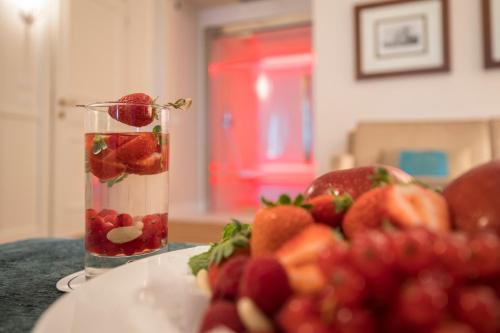 um vaso cheio de frutas ao lado de um prato de frutas em Grand Hotel Terme Sirmione em Sirmione