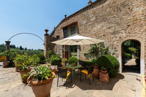 een patio met een tafel en een parasol voor een gebouw bij Villa Le Pergole- Firenze in Florence