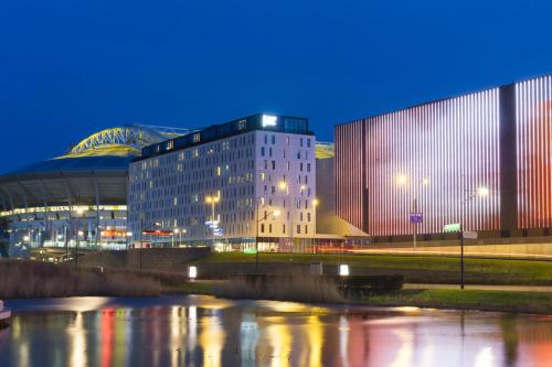 um edifício ao lado de um rio à noite em Jaz in the City Amsterdam em Amesterdão