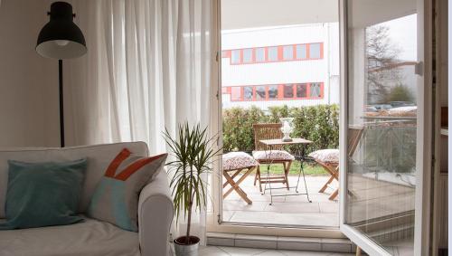 un salon avec un canapé et une terrasse avec une table dans l'établissement Gemütliche Wohnung mit sonniger Terrasse, à Bietigheim-Bissingen