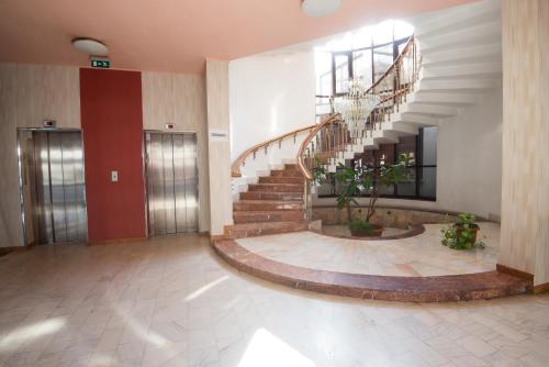 a lobby with a spiral staircase in a building at Hotel Victoria in Cluj-Napoca