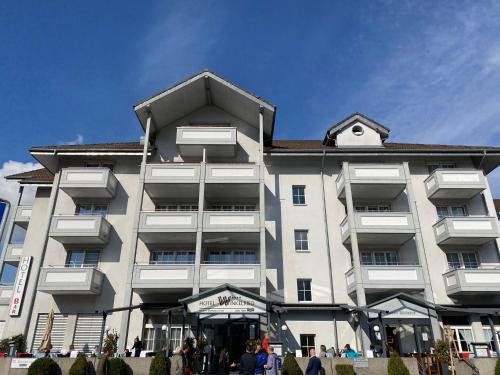 un grande edificio con persone che lo abitano fuori di Hotel Winkelried am See a Stansstad