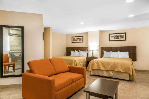 ein Hotelzimmer mit 2 Betten und einem Stuhl in der Unterkunft Quality Inn & Suites Middletown - Newport in Middletown