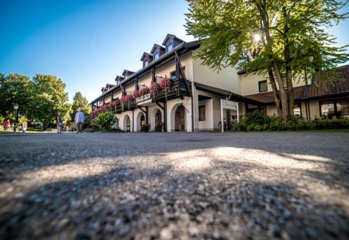 een groot gebouw met een boom ervoor bij Hotel Summerhof in Bad Griesbach