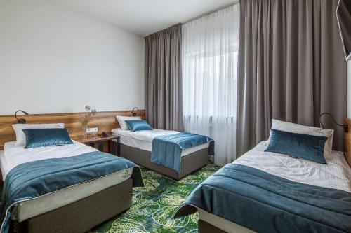 Una cama o camas en una habitación de Bloom Hotel Airport Okęcie