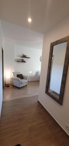 - un salon avec un canapé blanc et un miroir dans l'établissement Cherry Apartments - WIDOK, à Wałbrzych