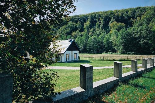 uma casa no meio de um campo com uma cerca em Pradnik Valley Lodge em Prądnik Korzkiewski