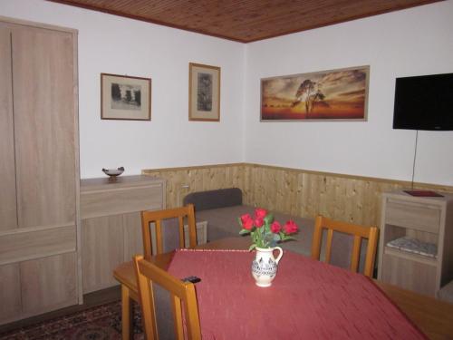 uma sala de jantar com uma mesa com um vaso de flores em Tóth Vendégház em Parád