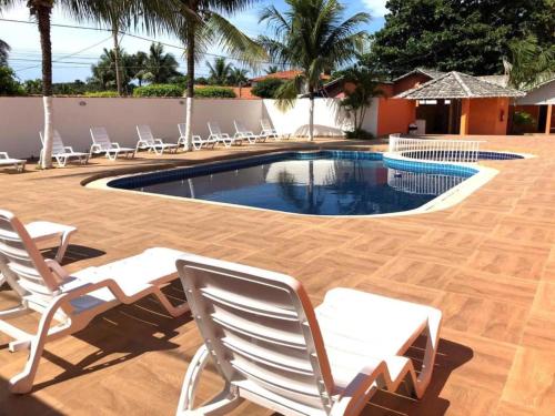 een zwembad met ligstoelen en een zwembad bij Villa Solarium Pousada in Cabo Frio