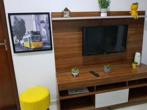 a living room with a television and a yellow stool at Carvalho de Paquetá in Rio de Janeiro