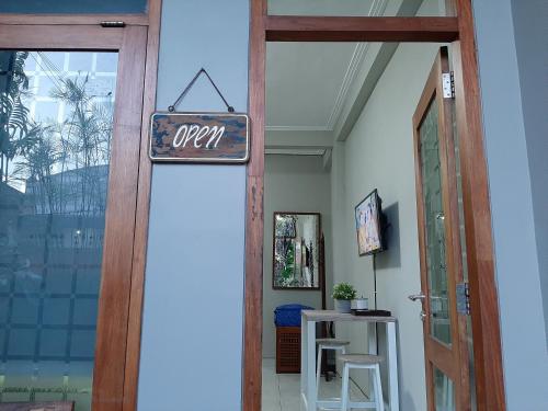 een open bord op de deur van een kamer bij rumah566 in Yogyakarta