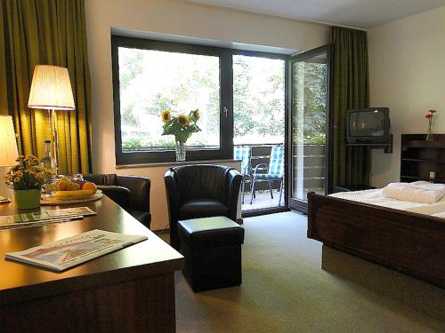 une chambre d'hôtel avec un lit, une table et des chaises dans l'établissement Hotel Zum Goldenen Hirsch, à Bad Bevensen