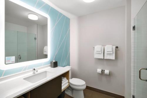 La salle de bains est pourvue d'un lavabo, de toilettes et d'un miroir. dans l'établissement avid hotels - Boston Logan Airport - Revere, an IHG Hotel, à Revere