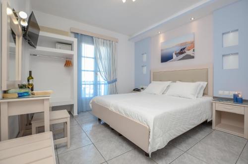 una camera bianca con letto e scrivania di Ilion Hotel a Naxos Chora