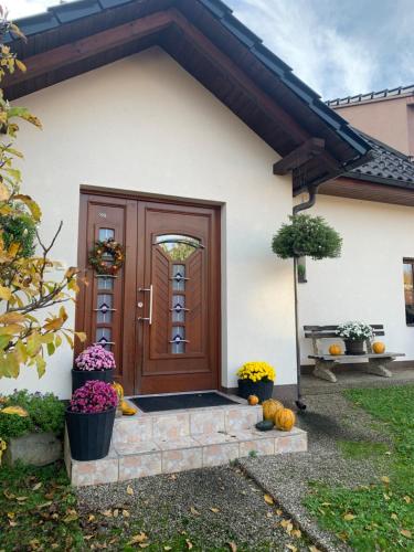 a house with a wooden door with pumpkins in front at Apartman Za Potokem in Luhačovice