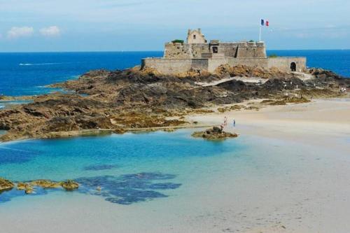 un château sur une île dans l'océan dans l'établissement Le Plongeoir de Bon-Secours, à Saint-Malo