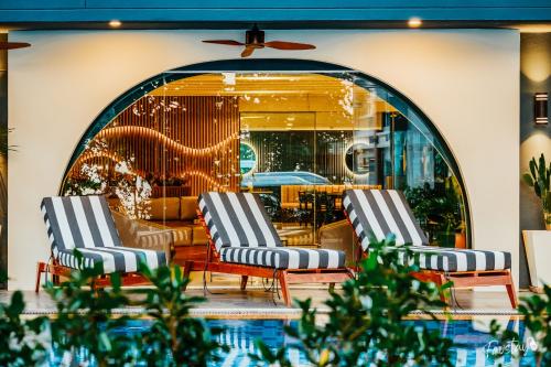 two lounge chairs and a pool in a building at So Boutique Jomtien Beach Pattaya in Jomtien Beach