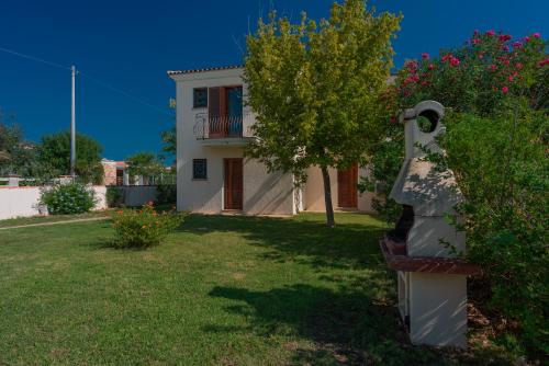 una casa bianca con un albero e un cortile di Le Dimore di Budoni a Budoni