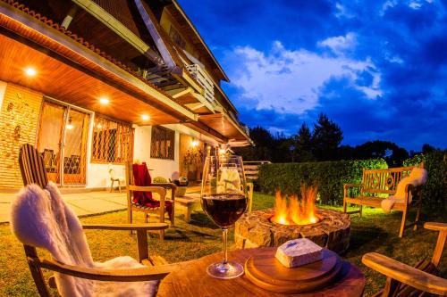 a glass of wine on a table next to a fire pit at Pousada das Lavandas in Campos do Jordão