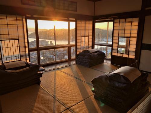 une chambre avec deux canapés dans une chambre avec fenêtres dans l'établissement Onomichi Guest House Miharashi-tei, à Onomichi