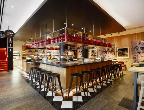 um bar num restaurante com bancos de bar em citizenM Washington DC Capitol em Washington