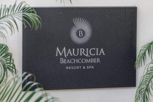 a black sign on a wall with plants at Mauricia Beachcomber Resort & Spa in Grand Baie