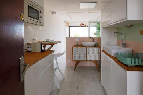 una piccola cucina con lavandino e bancone di Joli appartement village naturiste a Cap d'Agde