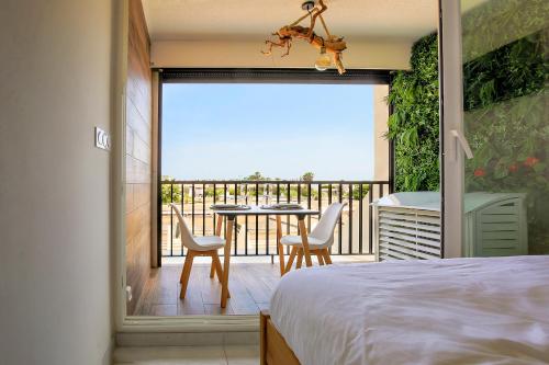 una camera da letto con balcone arredato con tavolo e sedie di Joli appartement village naturiste a Cap d'Agde