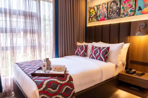 UNWND Boutique Hotel Makati في مانيلا: غرفه فندقيه بسرير ونافذه