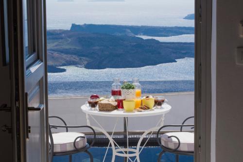 un tavolo con cibo e bevande su un balcone di Senses Suites a Imerovigli