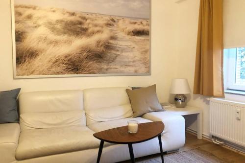 a living room with a white couch and a table at Gemütliche sanierte 1 Zimmer Wohnung mit privatem Parkplatz im Zentrum in Kiel