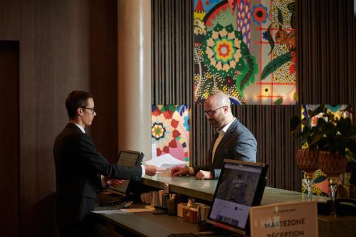 deux hommes serrent la main sur un bureau avec dans l'établissement BOUTIQUE Hotel by Continental Park, à Lucerne