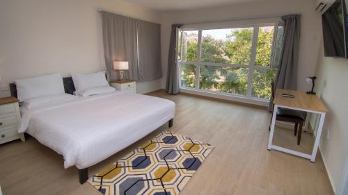 1 dormitorio con cama, escritorio y ventana en New Brookfields Hotel, en Freetown