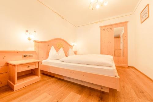 een slaapkamer met een groot bed en een tafel bij Residence Grüne Laterne - Lanterna Verde in Sesto