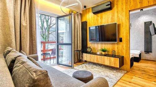 Televízia a/alebo spoločenská miestnosť v ubytovaní Apartament Wood Lux - 5D Apartamenty