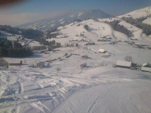 una montagna innevata con una piccola città di Rest. Beaver Creek Ranch a Rothenthurm