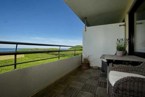 Cette chambre dispose d'un balcon avec vue sur l'océan. dans l'établissement Duenenhof-zum-Kronprinzen-Appm-60, à Wenningstedt