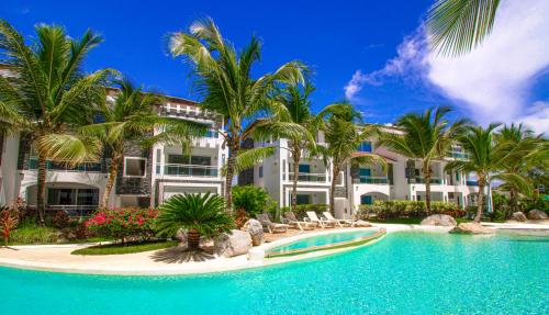 um resort com piscina e palmeiras em Atmospheric apartment with a beautiful view of the swimming pool em Bayahibe