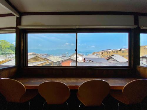 een raam in een kamer met een tafel en stoelen bij Ryoso Kawaguchi in Miyajima