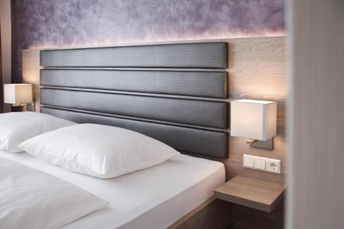 um quarto com uma cama com uma cabeceira preta em Hotel Rieth em Böblingen